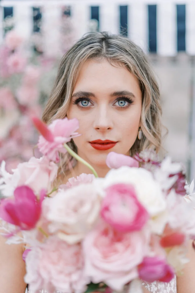 Woman with red lipstick on while holding flowers