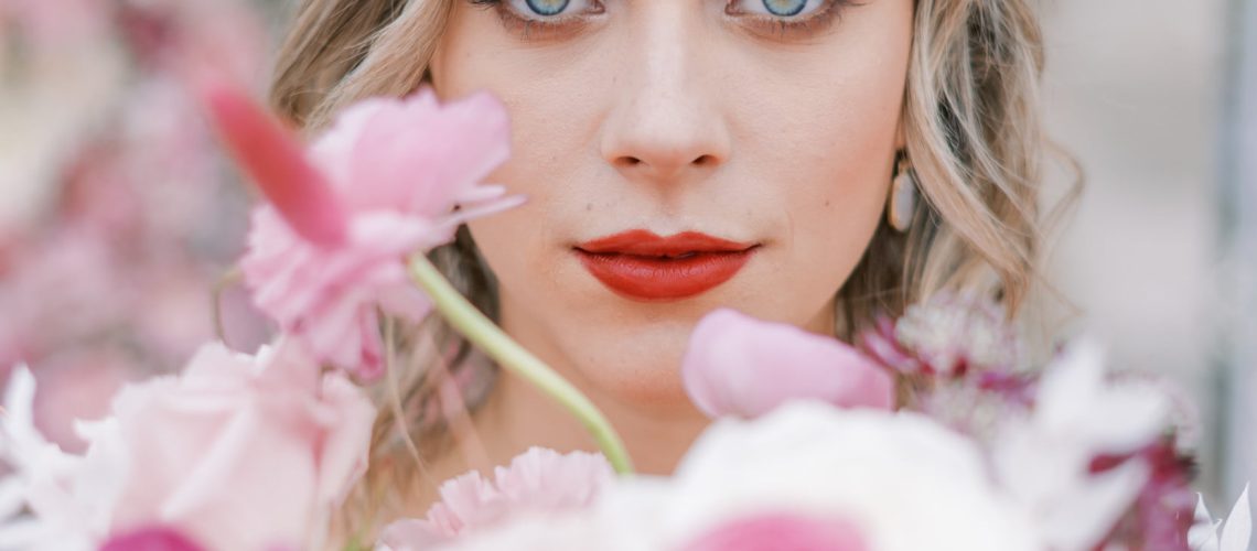 Woman with red lipstick on while holding flowers